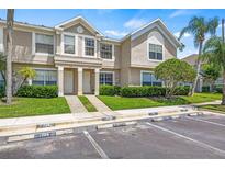 Inviting townhome exterior with lush landscaping, and designated visitor parking spaces at 732 Kensington Lake Cir, Brandon, FL 33511