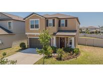 Charming two-story home featuring a well-maintained lawn, a garage, and inviting front entrance at 9411 Lemon Drop Loop, Sun City Center, FL 33573