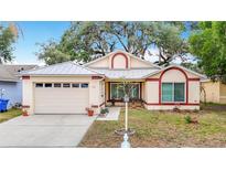 Charming one-story home with a metal roof, well-kept landscaping, and an attached two-car garage at 1432 Windjammer Pl, Valrico, FL 33594