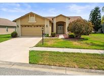 Charming single-story home with a well-manicured lawn and a two-car garage at 18514 Hidden Pines Way, Hudson, FL 34667
