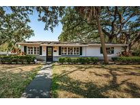 Charming single-story home featuring lush landscaping, a well-maintained lawn, and classic green shutters at 2880 81St N St, St Petersburg, FL 33710