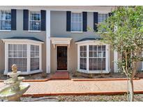 Charming two-story home featuring black shutters, beautiful bay windows, a brick walkway and an ornamental water fountain at 308 S Bungalow Park Ave # B, Tampa, FL 33609