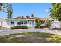 Charming single-story home boasts a classic style with well-maintained landscaping, a circular driveway, and a tiled roof at 3555 Belle Vista E Dr, St Pete Beach, FL 33706