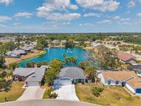 Aerial view of a charming single-Gathering home overlooking a lake with a fountain and lush landscaping at 3558 65Th Avenue E Cir, Sarasota, FL 34243