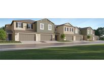 Charming townhome exterior with multiple garage doors and well-maintained landscaping at 36017 Joseph Blake St, Zephyrhills, FL 33541