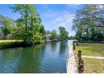 Scenic waterfront property with lush landscaping and a private dock on a canal at 5421 Gay St, Weeki Wachee, FL 34607