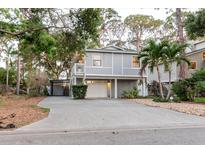 Charming two-story home featuring a spacious driveway and a well-maintained landscaped yard with trees at 138 69Th N Ave, St Petersburg, FL 33702