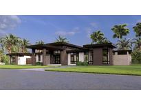 Stunning modern home with large windows and a grand entrance, surrounded by lush landscaping and palm trees at 19211 Gunn Hwy, Odessa, FL 33556