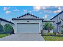 A charming one-story home with well-manicured landscaping, a two-car garage and brick paver driveway at 20092 Stone Pine Cir, Lutz, FL 33558