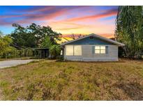 Charming one-story home with a cozy front yard and mature trees at sunset at 3614 Fortner Rd, Plant City, FL 33567