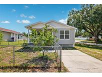 Charming single-story home featuring a fenced yard and inviting front porch, bathed in natural light on a sunny day at 3801 Carroway St, Tampa, FL 33619