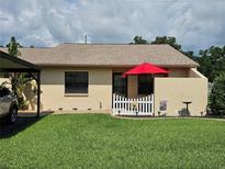 Charming single-story home with a well-manicured lawn and a cute, decorative white picket fence at 38225 Ironwood Pl # 38225, Zephyrhills, FL 33542