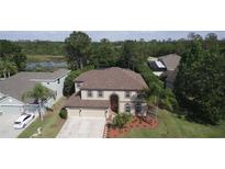 Charming two-story home featuring a well-maintained lawn, mature trees, and a two car garage at 7334 Night Heron Dr, Land O Lakes, FL 34637