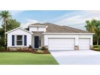 Stunning single-story home showcasing a three car garage, lush landscaping, and blue shutters with stone accents at 10652 Bridgegate Heights Loop, San Antonio, FL 33576