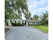 Charming single-story home with a gravel driveway and well-maintained landscaping at 1412 Sunset Ln, Lutz, FL 33549