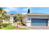 Modern home boasts a three-car garage, stone accents, and well-manicured landscaping at 1415 Beach Club, Apollo Beach, FL 33572