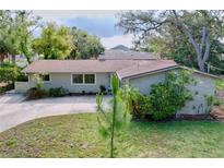 Charming single-story home featuring a well-maintained lawn, inviting curb appeal, and beautiful landscaping at 232 Pinecrest Dr, Palm Harbor, FL 34683
