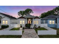 Charming home featuring a brick walkway, white picket fence, and delightful curb appeal at 260 Sw Lincoln N Cir, St Petersburg, FL 33703