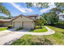 Charming home exterior with a two-car garage, well-maintained landscaping, and a walkway at 3066 Landmark Blvd # 1305, Palm Harbor, FL 34684