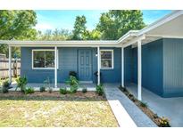 Charming home featuring a blue painted exterior with a well-manicured lawn and inviting curb appeal at 4516 W Paxton Ave, Tampa, FL 33611