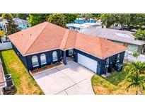 Charming single-story home featuring an attached garage and manicured front yard landscaping at 650 Arbor Ln, Largo, FL 33770