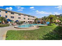 Outdoor pool with tanning chairs and green landscaping for a relaxed community feel at 6700 Sunset Way # 206, St Pete Beach, FL 33706