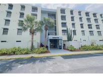 Exterior view of condo building 'South' entrance, featuring landscaping with palms and other plants at 701 S Madison Ave # 414, Clearwater, FL 33756