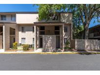Condo exterior shows two-story building with tan stucco, shaded entry, and Fire Lane painted on the asphalt at 7505 Pitch Pine Cir # 122, Tampa, FL 33617