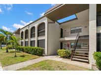 Exterior view of a two-story condo building featuring well-maintained landscaping and exterior staircases at 7701 Starkey Rd # 443, Seminole, FL 33777