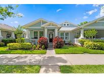 Charming craftsman-style home featuring a lush landscaped front yard and inviting covered porch at 9503 W. Park Village Dr, Tampa, FL 33626