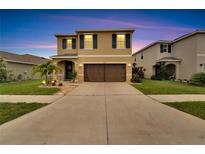 Inviting two-story home featuring a well-manicured lawn and a spacious driveway at 16815 Trite Bend St, Wimauma, FL 33598