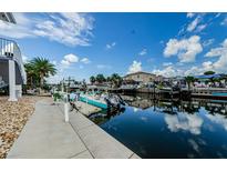 Scenic waterfront view featuring a private boat dock and canal access under a bright blue sky at 2186 Edythe Dr # 11, Dunedin, FL 34698