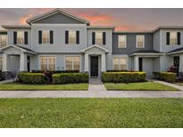 Charming townhome featuring a well-manicured lawn and inviting facade, perfect for modern living at 2432 Hearth Dr, Odessa, FL 33556