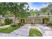Inviting townhome exterior with attached garages, mature landscaping, and a well-manicured lawn at 2746 Birchcreek Dr, Wesley Chapel, FL 33544