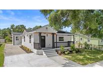 Charming renovated home boasting a freshly painted exterior, manicured landscaping, and welcoming front porch at 3215 E Powhatan Ave, Tampa, FL 33610