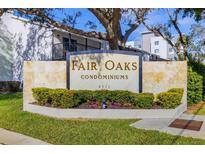 Fair Oaks Condominiums signage, landscaping, with building exterior elements are visible on a sunny day at 3823 N Oak Dr # K22, Tampa, FL 33611