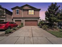 Charming two-story townhome with a double car garage and beautifully landscaped front yard at 5005 Blue Latan Ln, Tampa, FL 33610