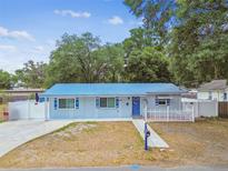 Charming single-story home with a vibrant blue roof and well-maintained landscaping at 504 E Lee St, Plant City, FL 33563