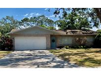 Charming brick home featuring a well-maintained front yard and an attached two-car garage at 5645 97Th N Way, St Petersburg, FL 33708