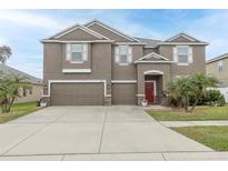 Charming two-story home with a three-car garage and a well-manicured lawn at 621 Washita Stone Dr, Ruskin, FL 33570