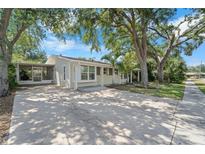 Charming single-story home with mature trees, long driveway, and a screened in porch at 6307 S Cameron Ave, Tampa, FL 33616