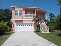 Charming home featuring a two-car garage, meticulous landscaping, and a grand staircase to a balcony at 6926 Mccray Dr, Hudson, FL 34667