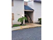 Exterior view of the building featuring light stucco and an entrance staircase at 7526 Needle Leaf Pl # 29, Tampa, FL 33617