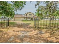 Charming two-story home with mature trees and a gated entrance, providing a serene and private setting at 8908 Hixon Rd, Tampa, FL 33626