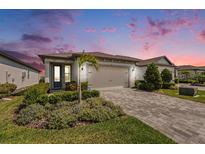 Charming single-story home featuring a well-manicured lawn and a brick-paved driveway at 10418 Spring Tide Way, Parrish, FL 34219