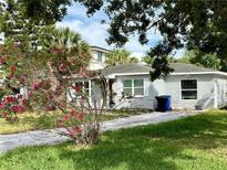 Charming single-story home featuring a well-maintained lawn and a beautiful flowering tree at 1910 New Hampshire Ne Ave, St Petersburg, FL 33703