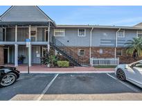 Two-story condo building with blue siding, brick accents, and accessible parking at 200 Country Club Dr # 403, Largo, FL 33771
