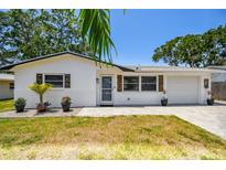 Charming single-story home boasts a brick facade, decorative shutters, and an inviting front entrance at 2004 Yale Ave, Dunedin, FL 34698