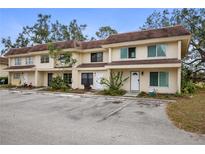 Inviting exterior view of a two-story townhome featuring an open parking area and a well-maintained lawn at 314 Barlow Ave # 73, Sarasota, FL 34232