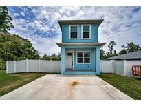 Charming two-story home featuring a quaint front porch, private white fence, and spacious front driveway at 3402 W Clifton St, Tampa, FL 33614